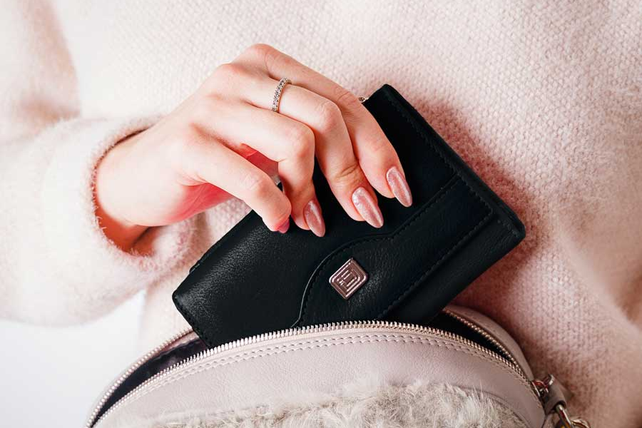 Womens wallet being place in purse
